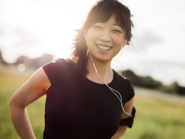 ISSA trainer smiling for a photo with wired earbuds